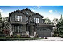 Charming two-story home with dark gray siding, stone accents, and a two-car garage at 7396 S Yank Ct, Littleton, CO 80127