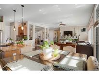 Well-lit dining room with hardwood table, decor, and an open layout to the kitchen and living room at 7186 Weaver Cir, Castle Rock, CO 80104