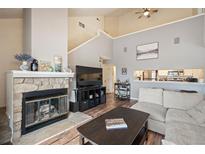 Inviting living room with vaulted ceilings, stone fireplace, and open layout into the kitchen at 3600 S Pierce St # 1-207, Denver, CO 80235