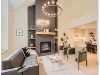 Bright living room with fireplace, hardwood floors, and a modern chandelier at 5206 S Meadow Lark Dr, Castle Rock, CO 80109