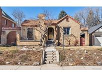Charming brick home with a tile roof, inviting entrance, and well-maintained landscaping at 1965 Jasmine St, Denver, CO 80220