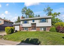 Charming two-story home with a well-manicured lawn, brick accents, and mature trees at 9430 Osceola St, Westminster, CO 80031