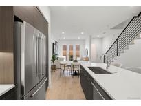 Modern kitchen with stainless steel appliances and an island that overlooks the dining area at 1815 N Williams St, Denver, CO 80218
