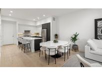 Bright, modern kitchen with stainless steel appliances, an island, and an adjacent dining area at 1815 N Williams St, Denver, CO 80218