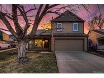 Charming home featuring a two-car garage, inviting front porch, and an American flag displayed proudly at 501 Entrada Dr, Golden, CO 80401