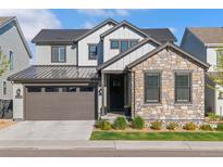 Beautiful two-story home with stone and siding, a well-manicured lawn and a two car garage at 11103 Cloud Shadow St, Littleton, CO 80125