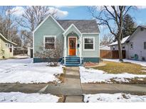Charming bungalow-style home featuring a vibrant orange front door and welcoming curb appeal in a neighborhood setting at 922 Pratt St, Longmont, CO 80501