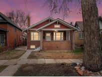Charming brick home with a cozy front porch and well-maintained yard at sunset at 361 S Logan St, Denver, CO 80209