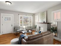 Cozy living room featuring a fireplace, hardwood floors, and large windows for natural light at 361 S Logan St, Denver, CO 80209
