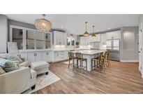 Bright kitchen features white cabinets, large island, and stainless steel appliances at 7706 S Duquesne Way, Aurora, CO 80016