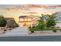 Charming two-story home boasts a well-manicured lawn and a welcoming entrance, perfect for Gathering living at 19894 W 94Th Ln, Arvada, CO 80007