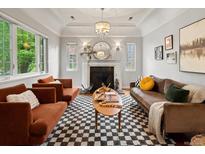 Bright living room with stylish fireplace, modern light fixture, and checkerboard rug at 405 S University Blvd, Denver, CO 80209