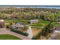 Expansive property featuring a main house, additional building, and large yard with views of the lake at 8280 Queen St, Arvada, CO 80005