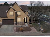Charming two-story home featuring a stucco facade, stone accents, and an attached two-car garage at 1890 Bel Lago Vw, Monument, CO 80132
