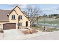 Charming home featuring a two-car garage, stone accents and manicured front yard at 1890 Bel Lago Vw, Monument, CO 80132