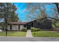 Stunning home with modern design elements, a red tiled roof, and a beautifully landscaped front yard at 5880 S Happy Canyon Dr, Cherry Hills Village, CO 80111