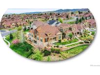Beautiful two-story home with lush landscaping, stone accents, and a mountain backdrop at 5781 S Union Ter, Littleton, CO 80127