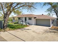 Charming home featuring a welcoming front porch and an attached two-car garage on a sunny day at 4972 Easley Rd, Golden, CO 80403