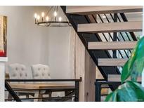 Modern staircase with wood steps, iron risers, and pendant lighting providing an architectural focal point at 24005 High Meadow Dr, Golden, CO 80401