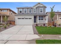 Charming two-story home with a well-manicured lawn and a spacious driveway leading to the garage at 24777 E 40Th Ave, Aurora, CO 80019