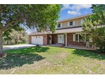 Charming two-story brick home with a well-manicured lawn and an attached two-car garage at 1808 Riverview Dr, Berthoud, CO 80513