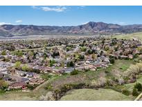 Expansive aerial view of neighborhood homes with beautiful mountain views in the distance on a sunny day at 2140 S Coors Cir, Lakewood, CO 80228