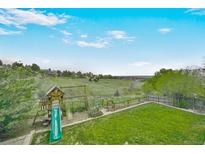 Expansive backyard featuring a playground and lush greenery, perfect for outdoor enjoyment at 2140 S Coors Cir, Lakewood, CO 80228