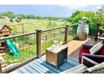 Outdoor deck featuring a seating area, blue rug, and a playset in the background with gorgeous natural views at 2140 S Coors Cir, Lakewood, CO 80228