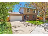 Charming two-story home with a brick facade, two-car garage, and well-maintained lawn at 3792 S Pitkin Ct, Aurora, CO 80013