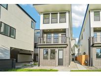 Modern two-story home showcasing a chic exterior, a small yard, and a sleek second-floor balcony at 1559 N Hooker St, Denver, CO 80204