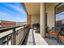 Spacious balcony with a view of the city, comfortable seating, and a grill for outdoor cooking at 20 Wilcox St # 208, Castle Rock, CO 80104