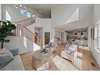 Bright living room featuring a modern staircase, wood floors, and lots of natural light at 5586 S Harlan St, Littleton, CO 80123