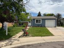 Charming single-story home featuring a well-manicured lawn, inviting front yard, and a paved driveway to the attached garage at 4259 S Richfield St, Aurora, CO 80013
