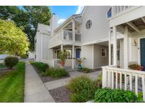Charming two-story townhome featuring a private balcony, blue front door, and well-maintained landscaping at 12593 E Pacific Cir # E, Aurora, CO 80014