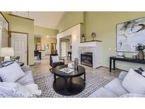 Inviting living room featuring a fireplace, vaulted ceiling, and an open floor plan at 9742 E Hawaii Pl, Aurora, CO 80247