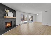 Bright living room with fireplace and sliding glass doors leading to a patio at 3369 S Monaco Street Pkwy # A, Denver, CO 80222