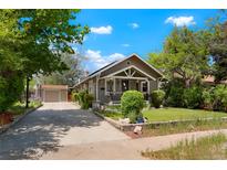 Charming home with mature trees, detached garage, and well-maintained front yard at 4779 S Bannock St, Englewood, CO 80110
