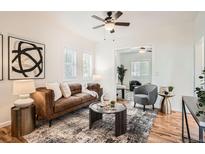 Bright living room with leather sofa, contemporary rug, and plenty of natural light at 2426 S Acoma St, Denver, CO 80223