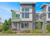 Modern two-story home with gray and green siding, and a front balcony at 4937 Tamarac St, Denver, CO 80238