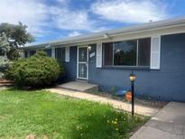 Charming blue brick home featuring well-kept lawn and decorative shutters at 598 Toledo St, Aurora, CO 80011