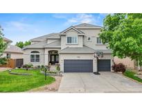 Charming two-story home featuring a well-manicured lawn and a three car garage at 9468 E Aspen Hill Ln, Lone Tree, CO 80124