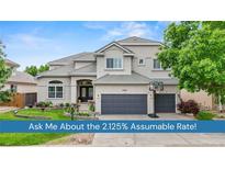 Charming two-story home features a well-manicured lawn, beautiful landscaping, and an attached two-car garage at 9468 E Aspen Hill Ln, Lone Tree, CO 80124