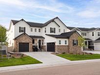Charming two-story home with a well-manicured lawn and a three-car garage, perfect for a growing Gathering at 6008 Long Branch Dr, Parker, CO 80134