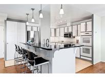 Modern kitchen features a black countertop island with seating and pendant lighting above at 3131 E Alameda Ave # 803, Denver, CO 80209