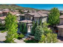 Beautiful two-story home with a stone and stucco facade, well-manicured landscaping, and a tile roof at 15235 W Iliff Ave, Lakewood, CO 80228