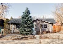 Charming single story home with gray siding, lush front yard, and inviting blue front door at 3939 Pecos St, Denver, CO 80211