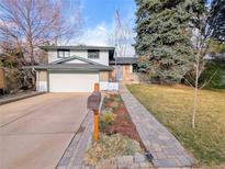 Charming two-story home with a well-manicured front yard, brick walkway, and attached two-car garage at 3326 S Geneva St, Denver, CO 80231