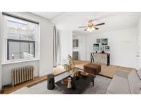 Bright living room featuring a ceiling fan, stylish decor, and a breakfast bar with sleek counter stools at 215 E 11Th Ave # D5, Denver, CO 80203