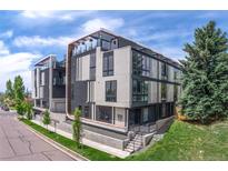 Modern condo building featuring striking architectural design with balconies and manicured landscaping at 5125 W 29Th Ave # 1, Denver, CO 80212