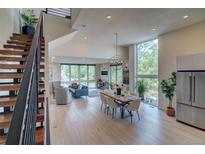 Open-concept living and dining area with modern decor, large windows, and stainless steel appliances at 5125 W 29Th Ave # 1, Denver, CO 80212